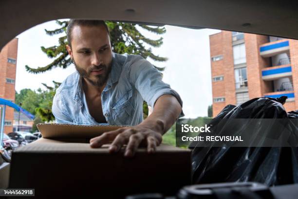 Latino Man Loading Boxes And Bags In The Back Of The Car Moving Concept Stock Photo - Download Image Now