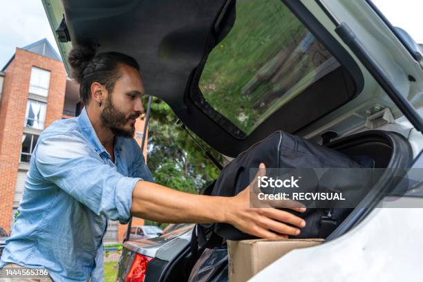 Latino Man Loading Boxes And Bags In The Back Of The Car Moving Concept Stock Photo - Download Image Now
