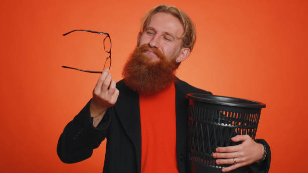 istock Smiling man taking off, throwing out glasses into bin after vision laser treatment therapy 1444569810