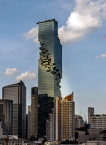 Bangkok, Thailand - 11 Nov 2022 : Architectural exterior view of King Power Mahanakhon Building is a mixed-use skyscraper with other modern high-rise buildings in central business district of Bangkok city. Geometric of modern high-rise buildings design with repeating structure, Selective focus.