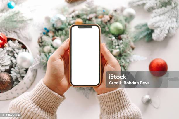 Phone With An Isolated Screen On The Background Of A Christmas Wreath The Concept Of A Festive Master Class Stock Photo - Download Image Now
