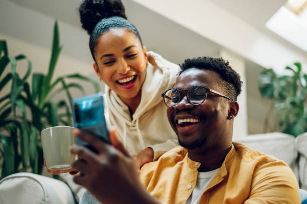 istock Multiracial couple at home while drinking coffee and using smartphone 1444572982