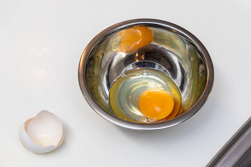 Raw egg in a metal bowl