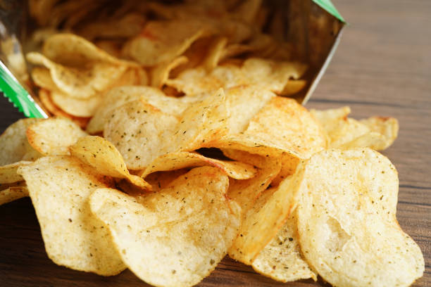istock Potato chips in open bag, delicious BBQ seasoning spicy for crips, thin slice deep fried snack fast food in open bag. 1444593479
