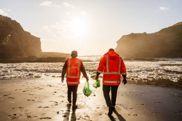istock Environmentally conscious men cleans up beach. 1444594936