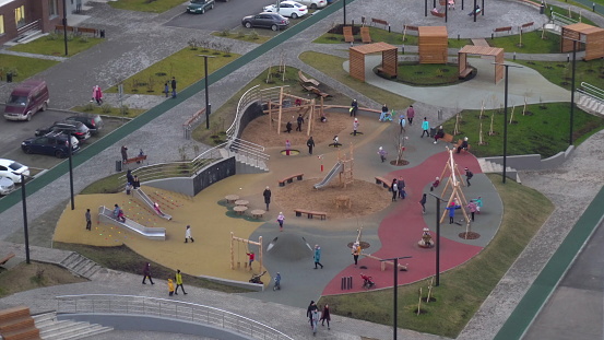 Children play on a dedicated site near the high-rise buildings. Top view of the playground. 4k
