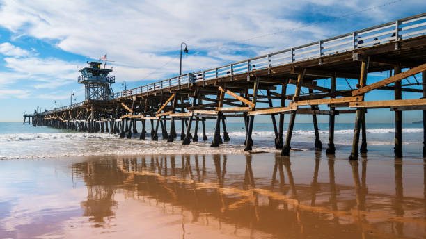 istock San Clement Pier at low tide with reflections on the shiny wet beach surface 1444603572