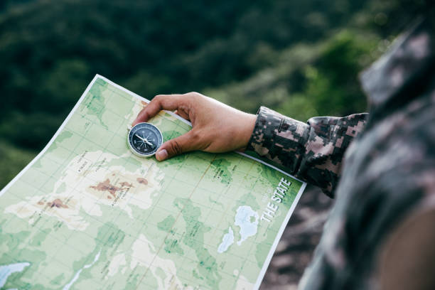 istock Soldiers holding compass and map for determines the location. 1444614586