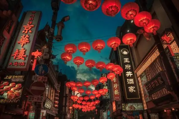 This image shows a Chinatown walkway with red lanterns illuminating a dark night sky.