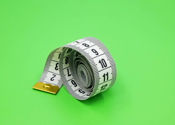 istock white measuring tape on a green background 1444632637
