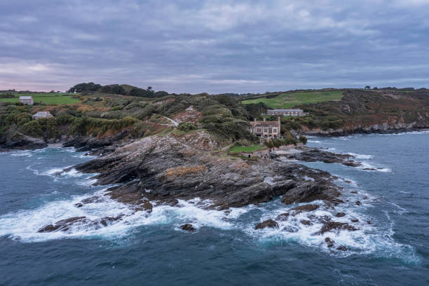 wunderschönes drohnen-landschaftsbild von prussia cove bei sonnenaufgang in cornwall england mit atmosphärischem daramatischen himmel und wolken - tide aerial view wave uk stock-fotos und bilder