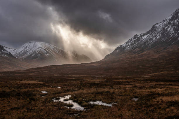Majestic dramatic Winter sunset sunbeams over landscape of Lost Valley in Etive Mor in Scottish Highlands stock photo