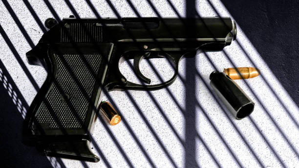istock Pistol with bullets behind the shadows. Book cover. 1444673486