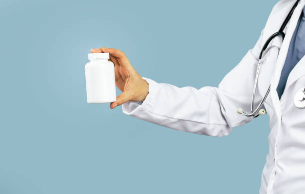 여성 의사의 손은 흰색 알약 항아리 모형을 보유하고 있습니다. 의학 및 약국 - prescription doctor rx pharmacist 뉴스 사진 이미지