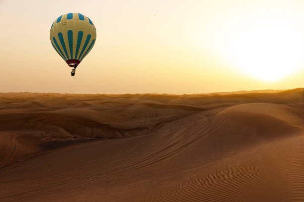 istock Hot air balloon in sand desert sunset landscape 1444682355