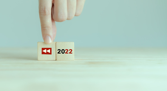 2022 Recapitulación economía, negocios, resumen financiero, concepto de revisión de negocios. Para la planificación empresarial en 2023. Replay icon y 2022 en cubos de madera sobre fondo gris inteligente y espacio de copia. photo