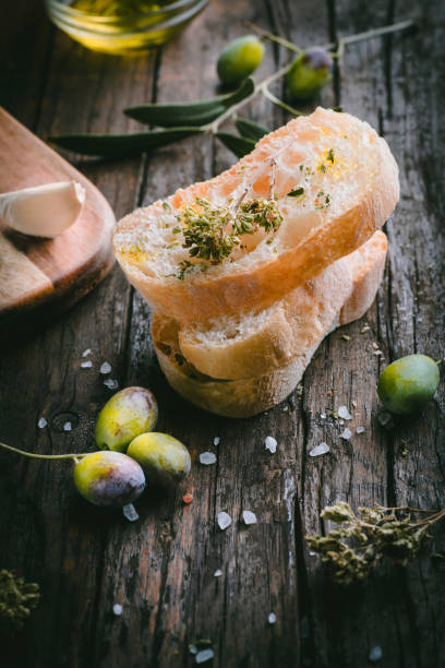 istock Italian Ciabatta bread with olive oil, salt and dried oregano. Simple bruschetta, basic Mediterranean cuisine. Olive season, rustic wooden background, 1444684473