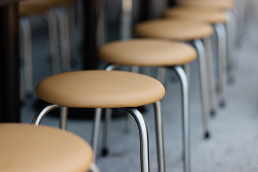 Small round beige padded stools in a row