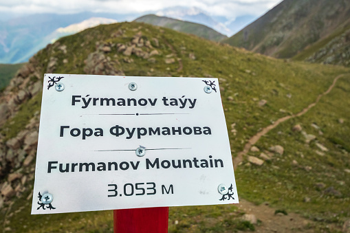Check point with signboard on top of Furmanov mountain in Almaty mountains of Kazakhstan nature.