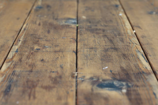 Part of an old wooden table with marks and scratches from years of use.