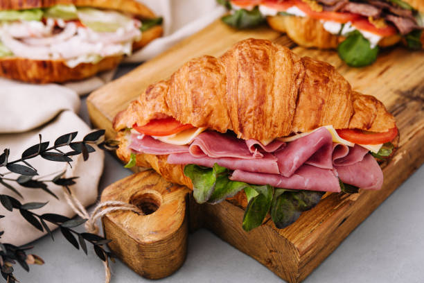istock Delicious croissant sandwich on wooden board 1444696830