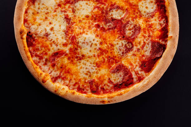 istock pizza with salami, parmesan cheese on black 1444696925