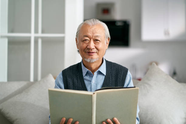 istock happy senior asian man reading a book at home 1444701898