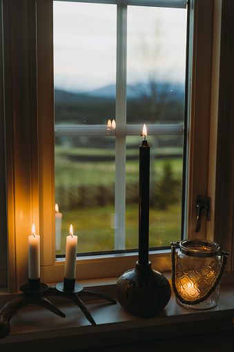 Scented candles on the windowsill with a view of the mountains and forest out of the window - a warm and cozy weekend in Norway