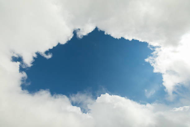 A piece of blue sky surrounded by white clouds.
