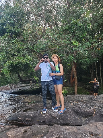 Diverse couple standing beside flowing stream in island