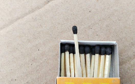 Macro shot of matchsticks coming out of the box to burn paper, matches stick on paper