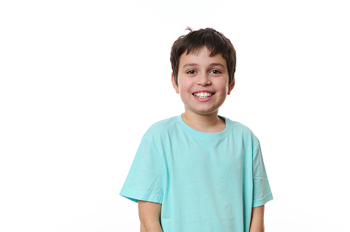 Emotional portrait of lovely Caucasian teen boy, smiling looking at camera, isolated on white background with free advertising space for your promotion. Smart schoolboy, teenager, pre-adolescent boy