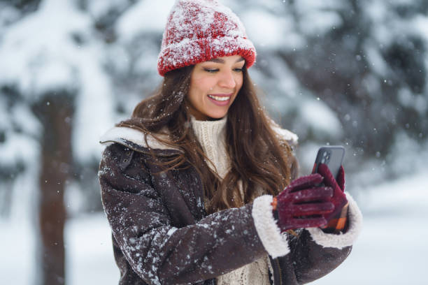 istock Happy woman taking selfie in winter forest. 1444711268
