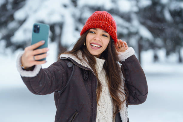 istock Happy woman taking selfie in winter forest. 1444711519
