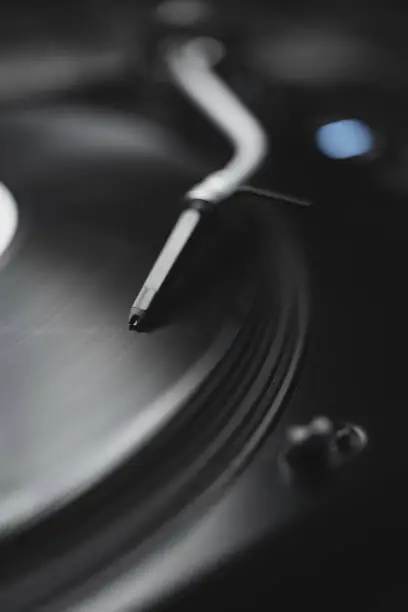 Professional DJ turn table player plays analog record with music in close up photo