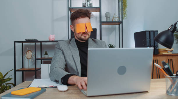 istock Inefficient tired lazy businessman working sleeping on laptop computer with eyes stickers on face 1444721070