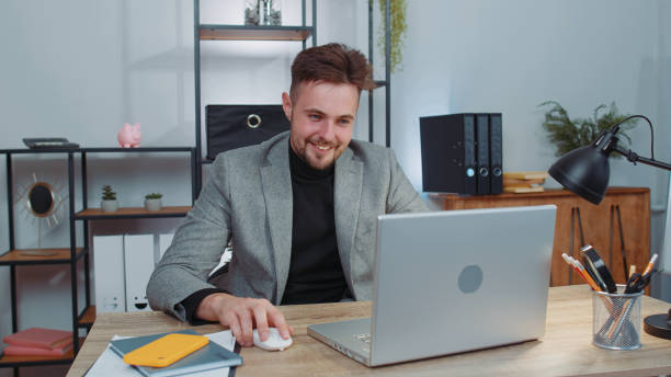 istock Businessman freelancer at office workplace, start working on laptop computer, sends online messages 1444721078