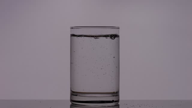Pouring water into transparent glass water concept