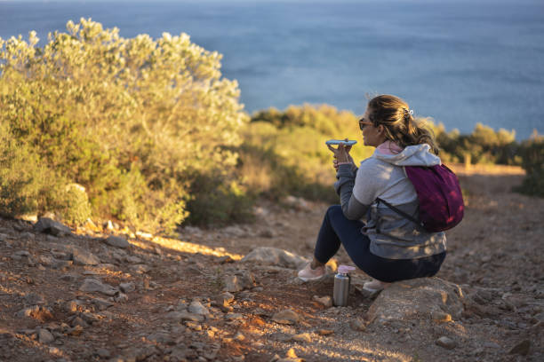 istock Woman sitting on rock sending voice message 1444725704