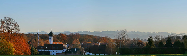 Bavaria, Germany. Panoramic view of our village at sunset with characteristic Bavarian blue sky and the alps at the background.