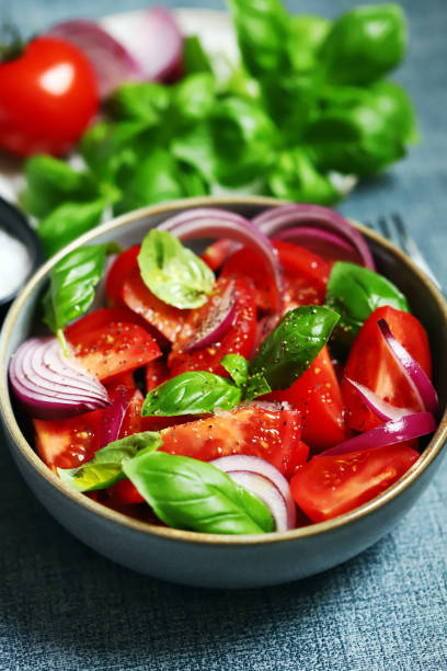 Juicy salad with tomatoes, basil and blue onion. stock photo