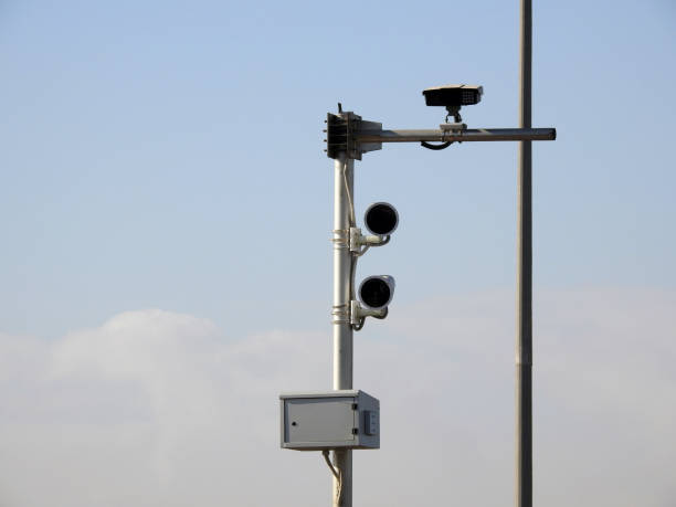 A roadside speed safety camera for supervision of the highways to detect and record the vehicles on the roads and the authority can catch the above speed limits, using mobile phones during driving, selective focus una cámara de seguridad de velocidad en carretera para la supervisión de las carreteras para detectar y registrar los vehículos en las carreteras y la autoridad puede captar los límites de velocidad anteriores, utilizando teléfonos móviles durante la