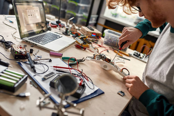 un technicien informatique ou un ingénieur en informatique répare partiellement un drone cassé - technician computer part it support work tool photos et images de collection