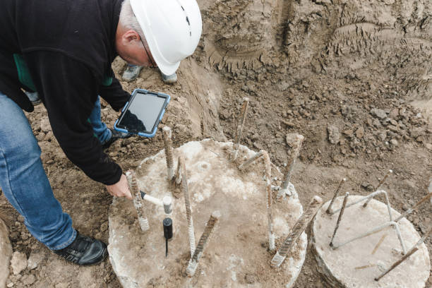 istock Construction works. Seismic test on concrete pile. Engineer using the PIT Hand-Held Hammer, the PIT Accelerometer and the Pile Integrity Tester to detect Neck Bulge and Void in the piles 1444738289