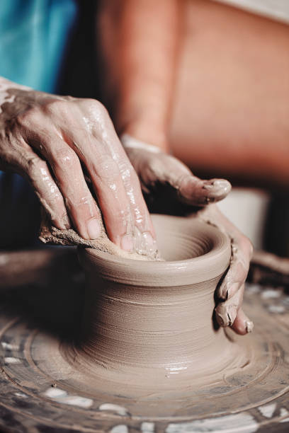 istock Woman hands working on pottery wheel and making a pot 1444738948
