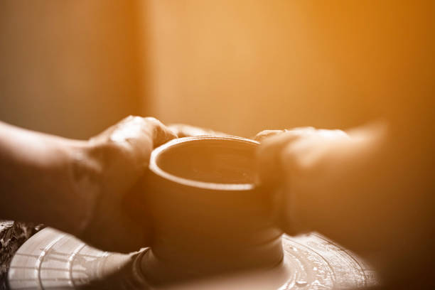 Woman hands working on pottery wheel and making a pot