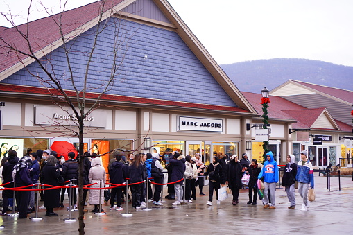 Woodbury, New York, United States - November 25, 2022 : people queuing in line to enter the store on Black Friday event at Woodbury common premium outlets, new york, united states