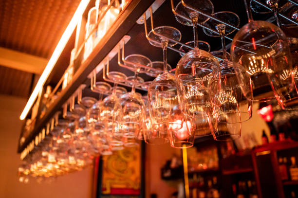 Empty upside-down crystal wine glasses hanging on the bar Empty upside-down crystal wine glasses hanging on the bar top counter in luxury restaurant. Nightlife dinner atmosphere and glassware concept wine bar counter stock pictures, royalty-free photos & images