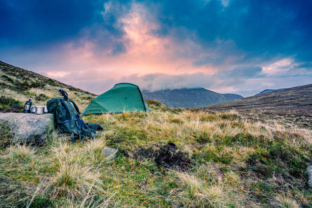 Solo camping tent pitched high in the mourne mountains under a heavy and dramatic sky