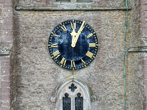 Drone view of a large clock seen at a church tower. A lightning conductor can be seen on the right hand side